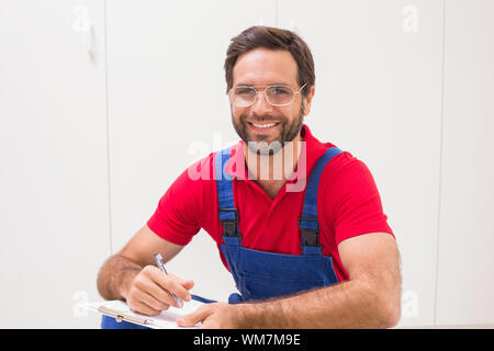 Construction worker taking notes on clipboard in a new house Stock Photo