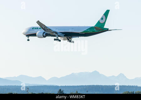 Eva Air Boeing 777 landing on a clear evening at the scenic Vancouver Intl. Airport. Stock Photo
