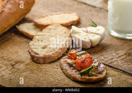 Bruschetta with Mediterranean vegetables fried in olive oil, garlic and fresh herbs Stock Photo