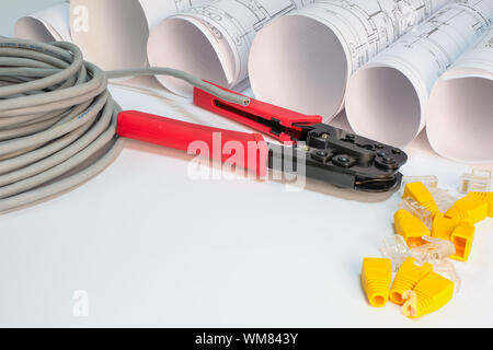 Drawing rolls, cat 5 cable, crimping pliers, connectors and boot caps Stock Photo