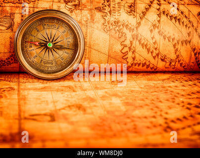 Vintage still life. Vintage compass lies on an ancient world map in 1565. Stock Photo