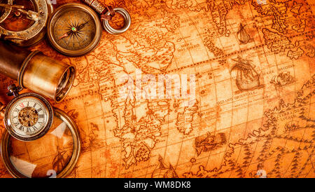 Vintage magnifying glass, compass, telescope and a pocket watch lying on an old map in 1565. Stock Photo