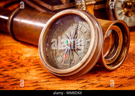 Vintage still life. Vintage compass lies on an ancient world map in 1565. Stock Photo