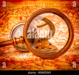 Vintage Compass and magnifying glass lies on an ancient world map ...