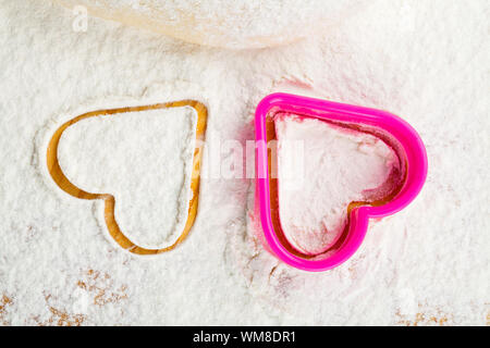 heart shaped cookie cutter on flour Stock Photo
