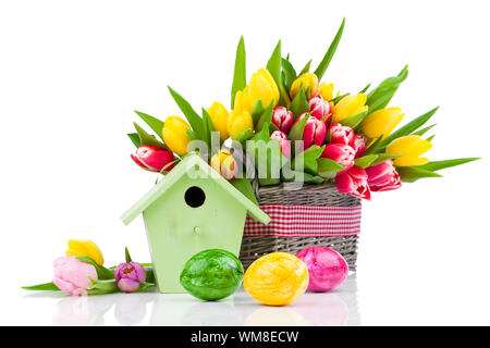 Easter eggs with tulips flowers and birdhouse, on a white background Stock Photo