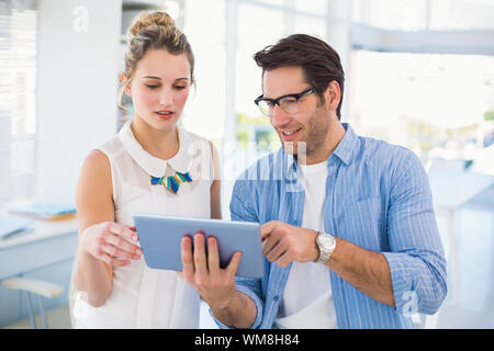 Cheerful photo editors working together on tablet pc in office Stock Photo