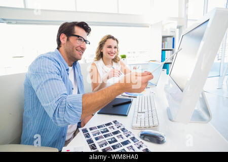 Photo editors working together on graphics tablet in office Stock Photo