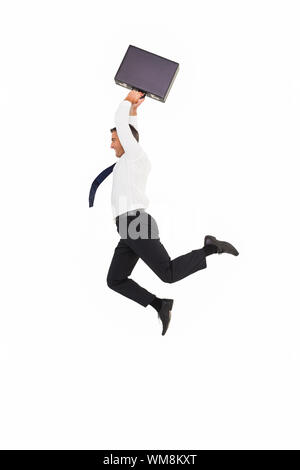 Smiling businessman leaping while briefcase on white background Stock Photo
