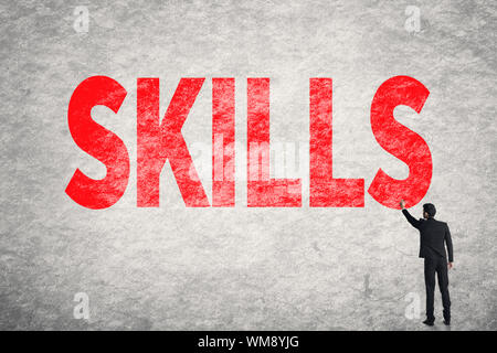 Asian business man write words on wall, Skills Stock Photo