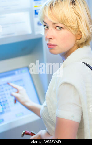 Lady buying a ticket at the vending machine Stock Photo