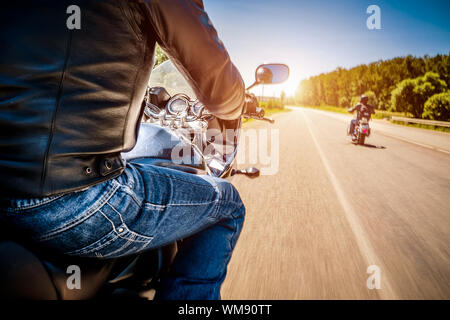 Bikers driving a motorcycle rides along the asphalt road (blurred motion). First-person view. Focus on the dashboard of a motorcycle Stock Photo
