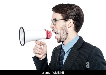 Angry businessman shouting into a megaphone Stock Photo