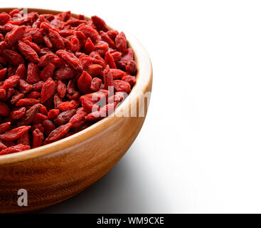 Wooden Bowl Full of Dried Goji Berries on the White Table. Healthy Diet Stock Photo