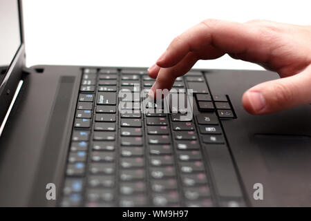 Close-up of finger over black laptop keys going to press enter button Stock Photo