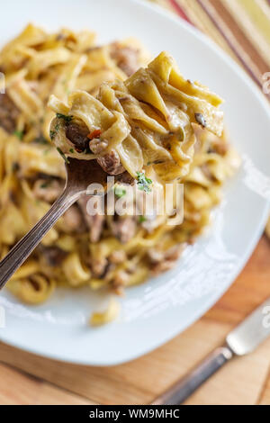 Fettuccine stroganoff with steak mushrooms and crumbled sausage Stock Photo