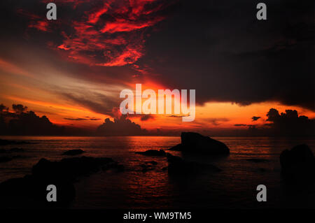 Sun rising over water horizon at Teluk Cempedak (Jackfruit Bay), a famous beach in Kuantan, Pahang, Malaysia, Asia. Stock Photo