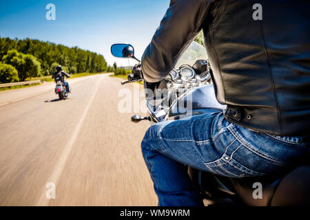 Bikers driving a motorcycle rides along the asphalt road (blurred motion). First-person view. Focus on the dashboard of a motorcycle Stock Photo