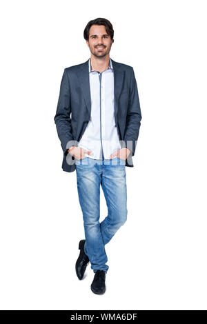 Serious thoughtful handsome young man standing facing the camera with his hands in his pockets isolated on white Stock Photo