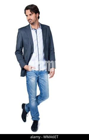 Serious thoughtful handsome young man standing facing the camera with his hands in his pockets isolated on white Stock Photo