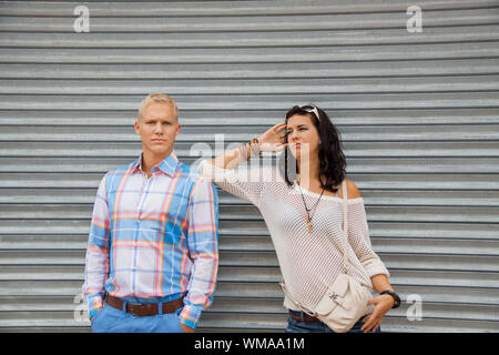 Fashionable couple posing in front of a metal door Stock Photo