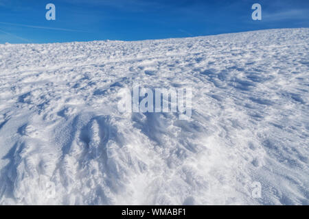 Fresh sparkling snow cover on mountain tops. Blue sky at the background. Stock Photo