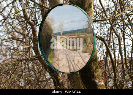 Reflection from a roadside safety mirror on a hedge-lined lane in Hertfordshire, England Stock Photo