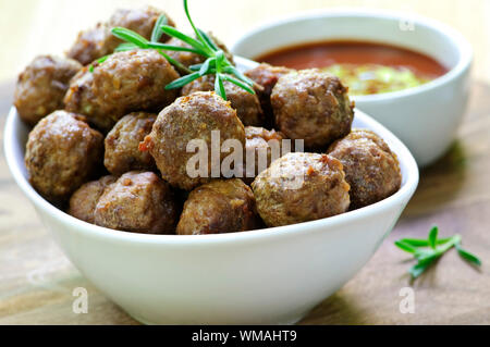 Fresh hot meatball appetizers served in white bowl with dipping sauce Stock Photo