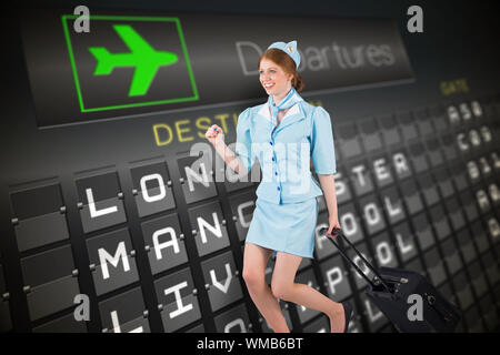 Pretty air hostess pulling suitcase against black departures board for england Stock Photo
