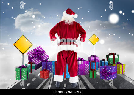 Santa Claus against road over clouds with road signs on it Stock Photo