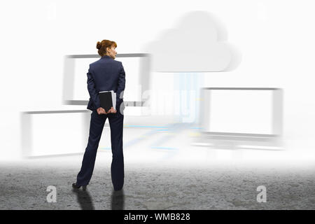 Businesswoman looking against cloud computing graphic over sand Stock Photo