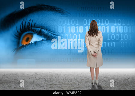 Rear view of businesswoman against eye with binary code over desert Stock Photo