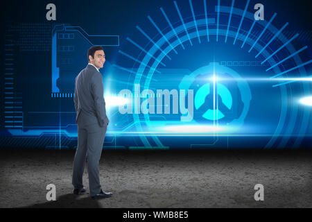 Smiling businessman standing against blue glowing interface Stock Photo