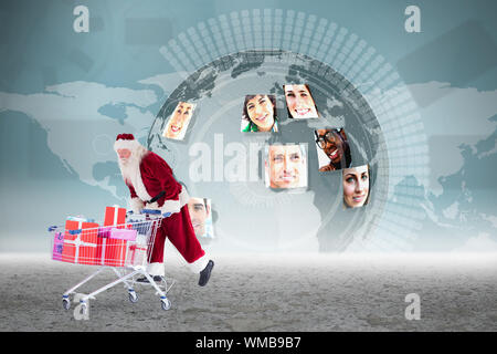 Santa pushing a shopping cart against global business partners graphic Stock Photo