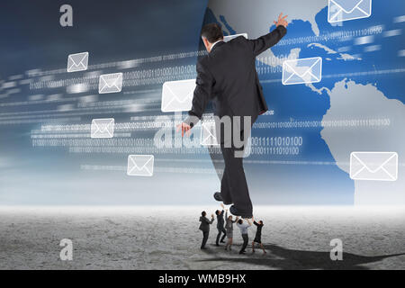 Business people supporting boss against email graphics against earth Stock Photo