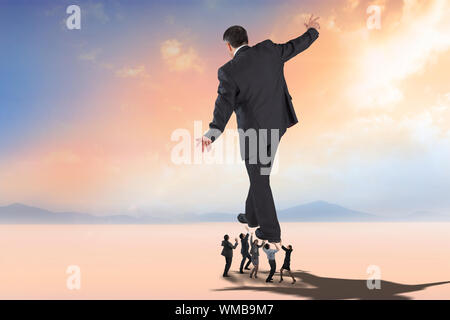 Business people supporting boss against desert landscape Stock Photo