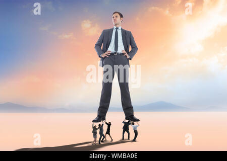 Business people supporting boss against desert landscape Stock Photo