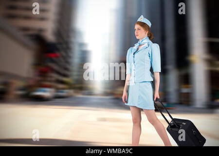 Pretty air hostess pulling suitcase against new york street Stock Photo
