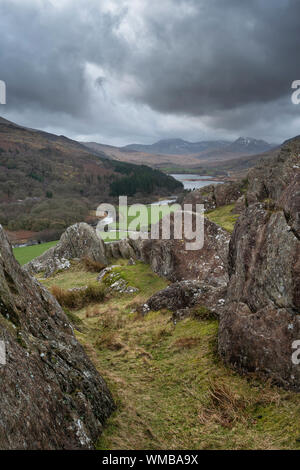 Winter landscape image of the view from Crimpiau and The Pinnacles towards Llynnau Mymbyr and snowcapped Snowdon in the distance Stock Photo