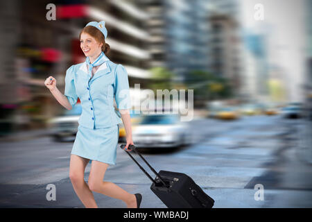 Pretty air hostess pulling suitcase against new york street Stock Photo