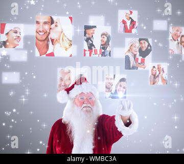 Santa Claus points at something against grey vignette Stock Photo
