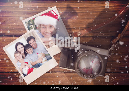Composite image of christmas memories against instant photos on wooden floor Stock Photo