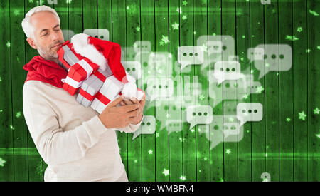Happy festive man with gifts against star pattern on green planks Stock Photo