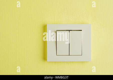 Electric switch with space for text on yellow wall. Stock Photo