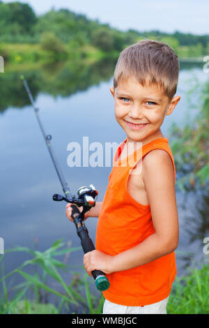 Summer vacation - Photo of little boy fishing on the river. Stock Photo