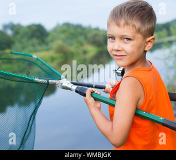 Summer vacation - Photo of little boy fishing on the river. Stock Photo