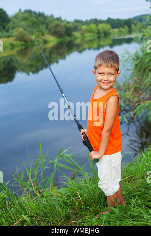 Summer vacation - Photo of little boy fishing on the river. Stock Photo