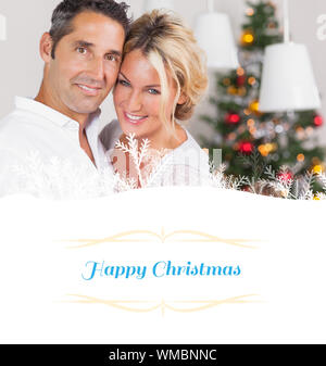 Composite image of couple embracing at christmas against border Stock Photo