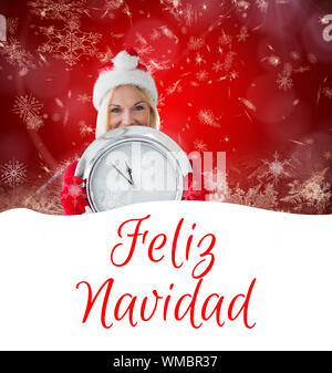 happy festive blonde with clock against feliz navidad Stock Photo