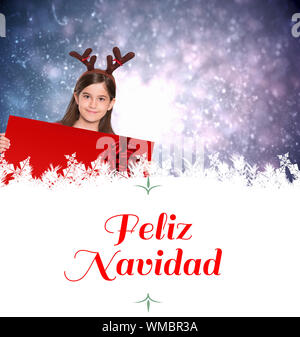 Composite image of festive little girl showing card against Christmas greeting Stock Photo